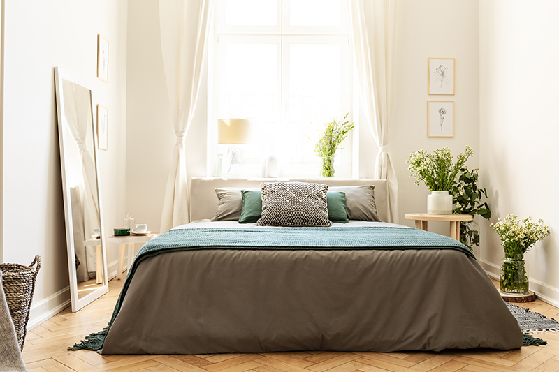 Luminosa e accogliente camera da letto con un letto matrimoniale posizionato davanti a un'ampia finestra